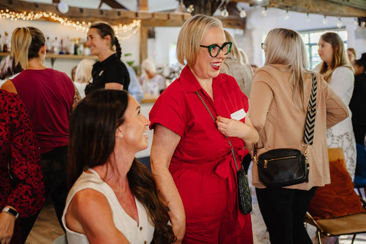 Woman in a red outfit standing among other people at an event. 1