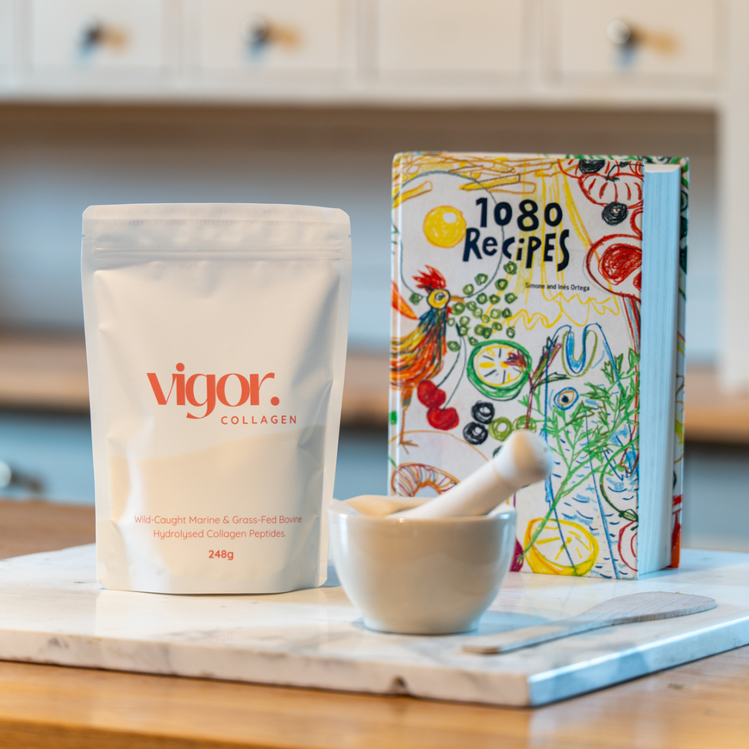 Vigor collagen pouch and a colourful cookbook on a kitchen counter