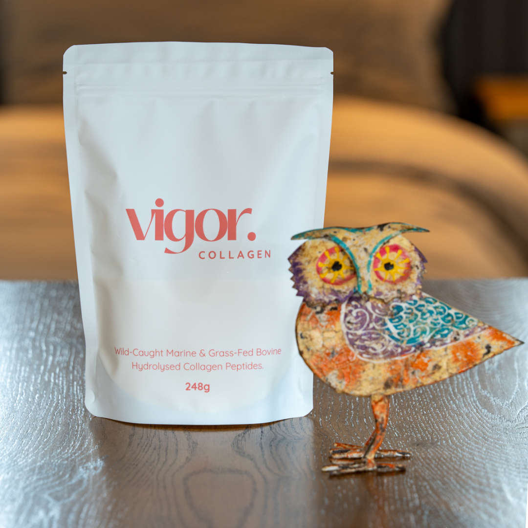 Vigor collagen package on a wooden surface with a decorative owl figurine.